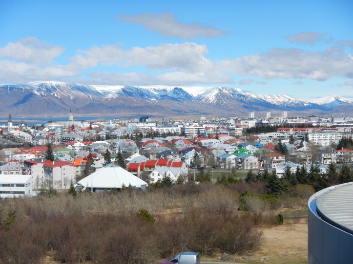 A view from Perlan's observation deck of the city and volcanic mountains.  Note the colorful buildings - there are no color regulations for painting homes and businesses, so the people of Iceland like to use a range of color, and much of it!