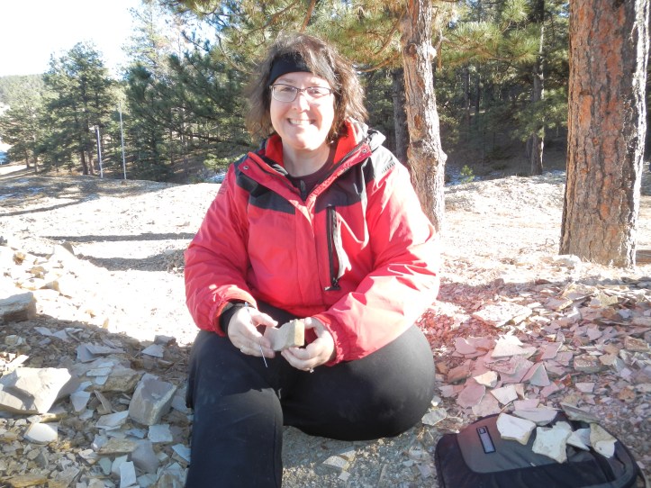 Sitting and splitting paper shale, looking for fossils, at Florissant Fossil Quarry