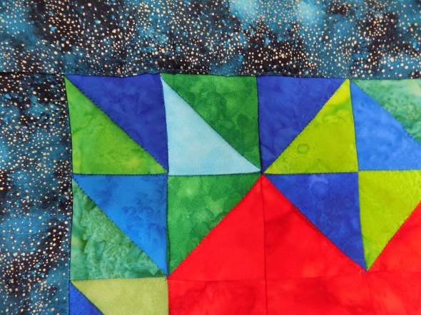 Close-up of blue and green batik fabrics included in the quilt I HeART Earth Science