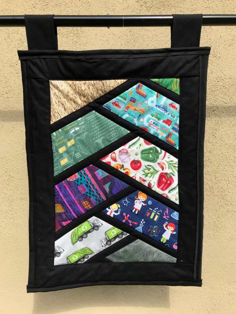 Overview - Project Drawdown. Completed March 14, 2021, measures 18 inches across by 24 inches in height. Sashed half hexi pattern.