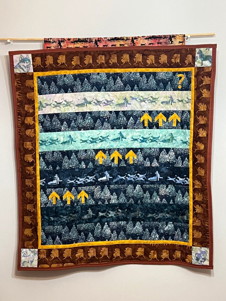 Large quilt with batik fabric hanging