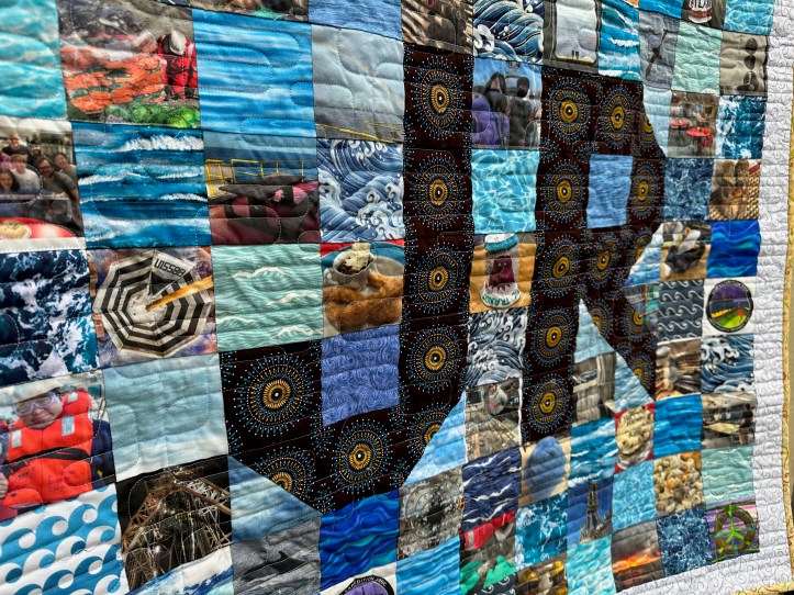 Close of of hanging quilt with fabric squares of different patterns