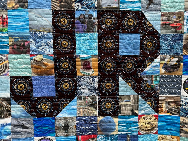 Close of of hanging quilt with fabric squares of different patterns