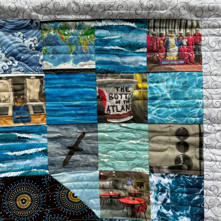 Close of of hanging quilt with fabric squares of different patterns