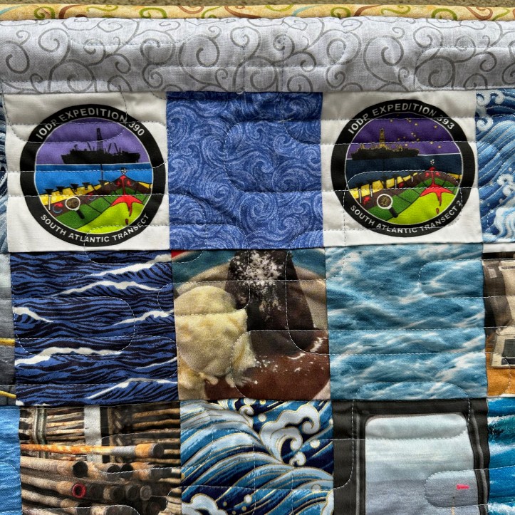 Close of of hanging quilt with fabric squares of different patterns