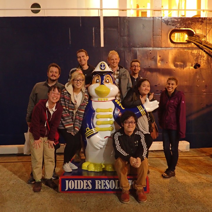 group photo around a penguin statue
