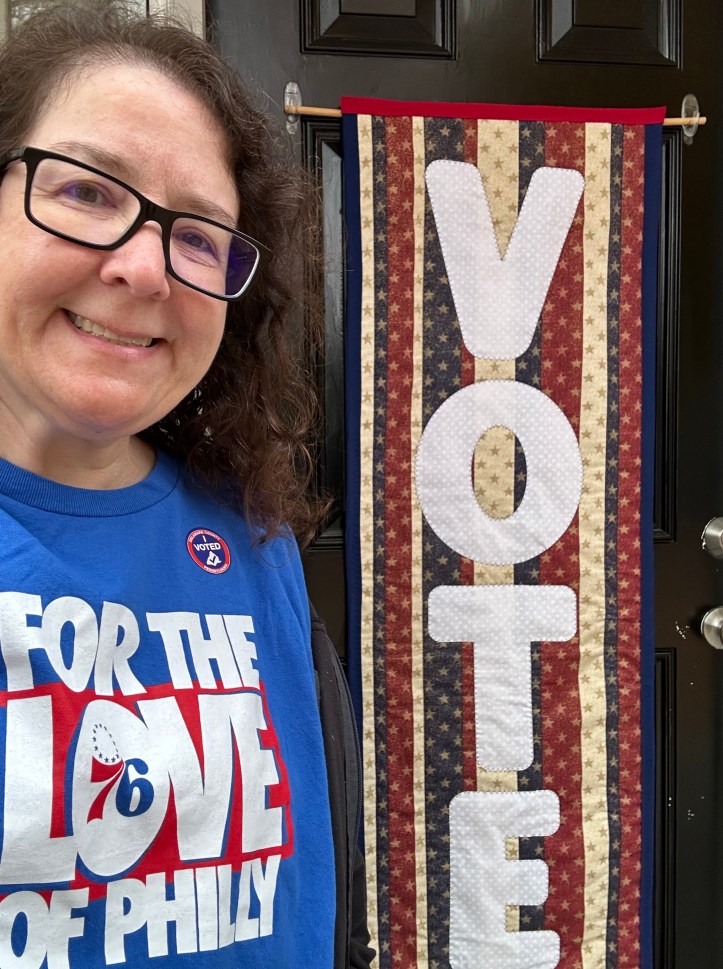 Person standing in front of a quilt hanging on a door
