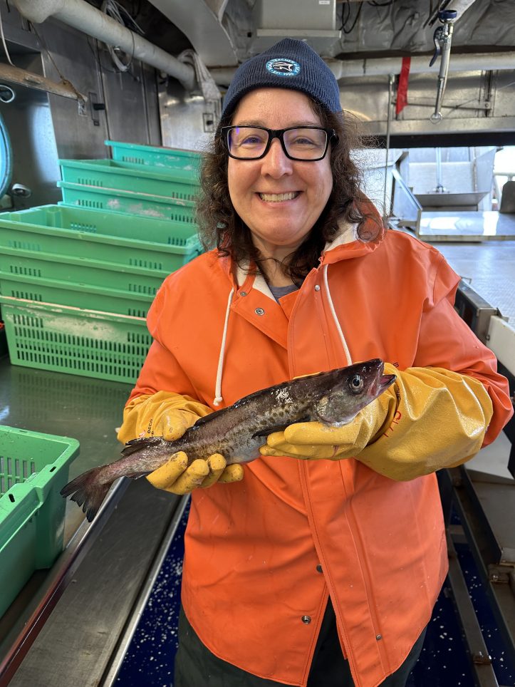 Person holding a fish on a ship