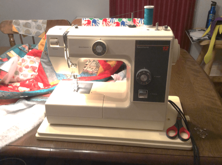 sewing machine on a table with a quilt project in-progress