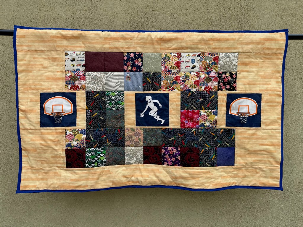 Front of a hanging quilt with basketball fabric and Japanese fabric