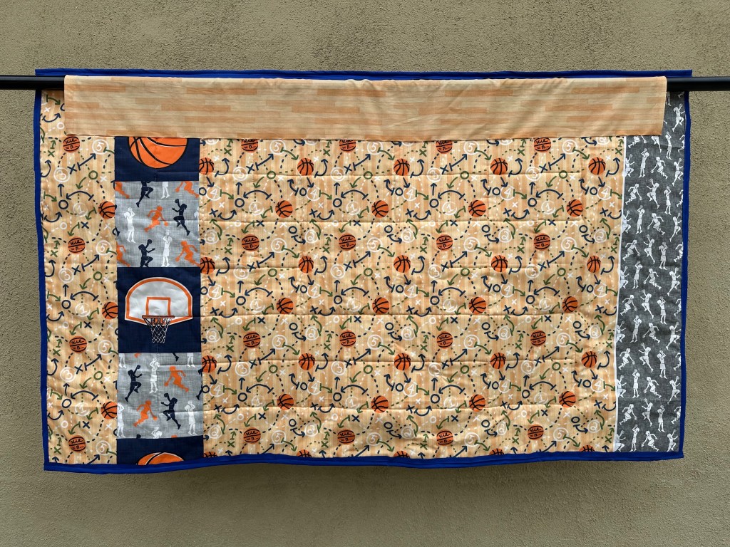 Back of a rectangular hanging quilt with basketball fabric