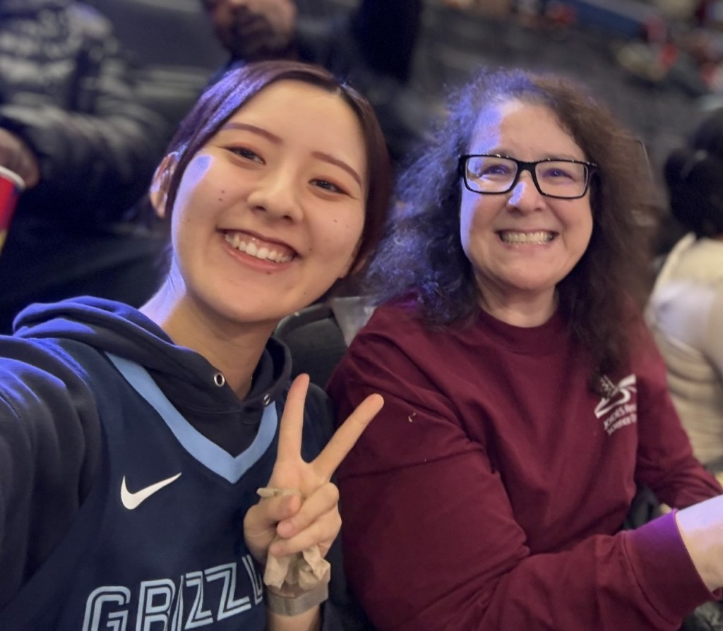 Two people sitting next to each other smiling at the camera for a selfie